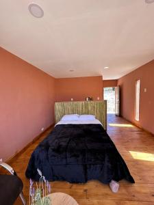 een slaapkamer met een groot bed in een kamer bij AMA WARA in Maimará
