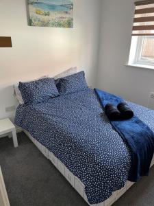 a bedroom with a bed with blue sheets and pillows at April Disc - Long Stay - Contractors in Bristol