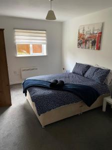 a bedroom with a bed with a blue comforter and a window at April Disc - Long Stay - Contractors in Bristol