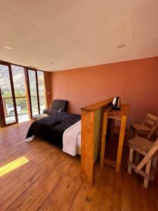 - une chambre avec un lit et un bureau avec une chaise dans l'établissement AMA WARA, à Maimará