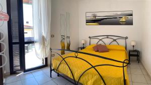 Un dormitorio con una cama amarilla y una ventana en Affittacamere MADE IN PISA Locazione Turistica, en Pisa