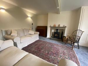 sala de estar con sofá blanco y chimenea en Sandholme Cottage - Pateley Bridge, en Pateley Bridge