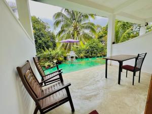 a dining room with a table and chairs and a pool at GOLDEN CABIN ELLA in Ella