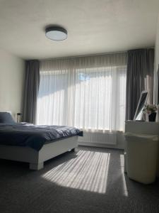 - une chambre avec un lit et une grande fenêtre dans l'établissement Weekend apartment, à Sigulda