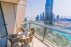 een balkon met een tafel en stoelen op een wolkenkrabber bij LUXFolio Retreats - Amazing Full Burj Khalifa View in Dubai