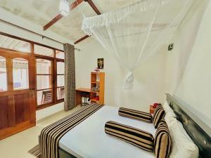 a bedroom with a bed with a mosquito net at GOLDEN CABIN ELLA in Ella