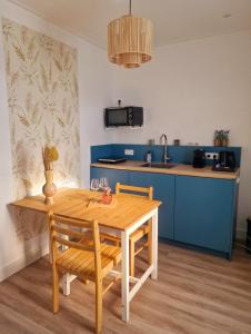 Studio Flevo Batavia في ليليستاد: مطبخ مع طاولة خشبية مع كرسيين