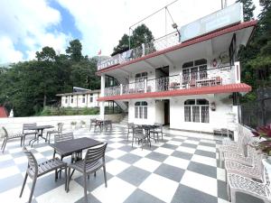 a patio with tables and chairs in front of a building at HOTEL PRINCE ! NAINITAL Mall Road-prime-location in-front-of-Naini-lake hygiene-and-spacious-room in Nainital