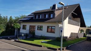 een wit huis met zonnepanelen op het dak bij Haus Weinheck in Lebach