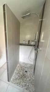 La salle de bains est pourvue d'une douche et d'un sol en pierre. dans l'établissement La pause en luberon, à Cavaillon