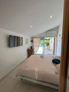 a bedroom with a large bed and a tv on the wall at La pause en luberon in Cavaillon
