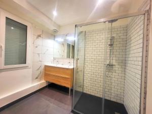 ein Bad mit einem Waschbecken und einer Glasdusche in der Unterkunft Maison de charme in Toulouse