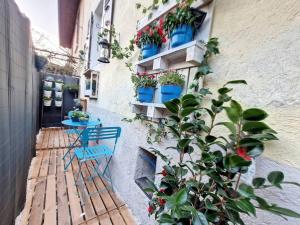 a patio with a blue chair and potted plants on a building at Les Dames YourHostHelper in Gières
