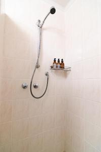 a shower with three bottles on a shelf in a bathroom at Zi Wu Self Catering Apartment in Swakopmund