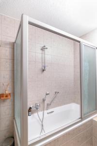 a bath tub with a shower in a bathroom at Zi Wu Self Catering Apartment in Swakopmund