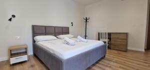 una camera da letto con un grande letto con due cuscini sopra di Kutal Parkinn Hotel a Përmet