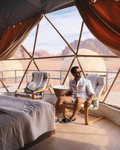 a man sitting in a chair in front of a window at Wadirum winter in Wadi Rum