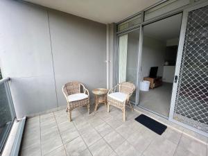 un patio con 2 sillas y una mesa en el balcón en Westmead Home away from home, en Westmead