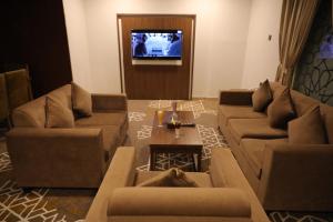 uma sala de estar com sofás e uma televisão de ecrã plano em Taj Al-Wajh Hotel em Al Wajh