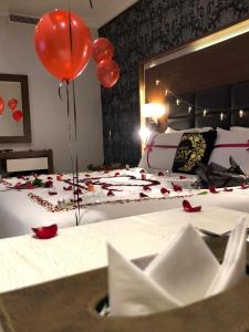 a bedroom with a bed with red balloons and roses on it at Taj Al-Wajh Hotel in Al Wajh
