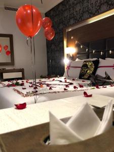 a bedroom with a bed with red balloons and roses on it at Taj Al-Wajh Hotel in Al Wajh +27 photos