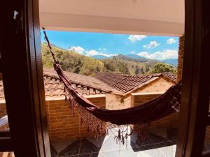 a hammock hanging from a window of a building at Pousada Cantinho da Montanha in Visconde De Maua