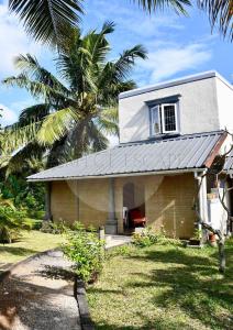 ein kleines Haus mit einer Palme davor in der Unterkunft Perfect Escape - Oasis de calme à 300m de la plage in Poste Lafayette