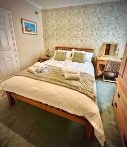 a bedroom with a large bed with towels on it at A charming luxury apartment! in Portinscale