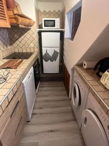 a small kitchen with a refrigerator and a microwave at logement atypique Menton in Menton