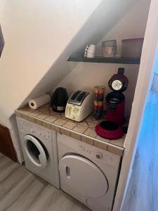 a washer and dryer in a kitchen with a shelf at logement atypique Menton in Menton