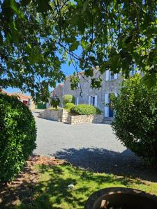 une grande maison est vue à travers les feuilles d'un arbre dans l'établissement La Commanderie Grand Gite 10kms " Puy duFou", à Mauléon