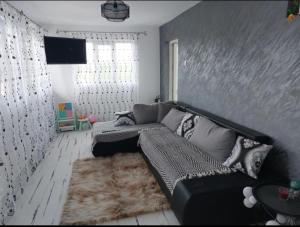 - un salon avec un canapé et une télévision dans l'établissement Casa dintre munti, à Novaci-Străini