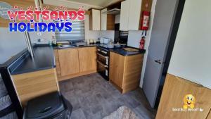 a small kitchen with a sink and a stove at 3 Bedroom Caravan at Seal Bay Resort in Selsey