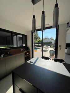 a kitchen with a table and a view of a yard at Villa haut standing avec piscine in Gradignan