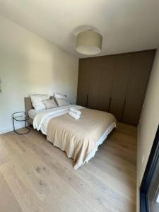 sypialnia z dużym białym łóżkiem i drewnianą podłogą w obiekcie Villa haut standing avec piscine w mieście Gradignan
