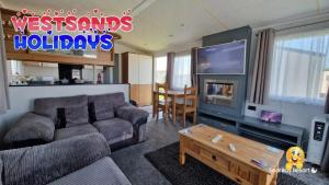 a living room with a couch and a tv at 3 Bedroom Caravan at Seal Bay Resort in Selsey