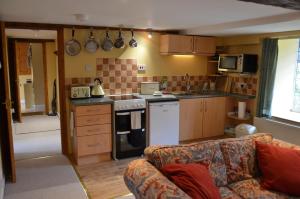 a kitchen with a couch in a living room at Hafannedd in Corwen +21 photos