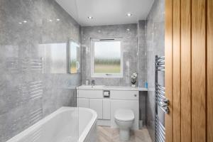łazienka z wanną, toaletą i umywalką w obiekcie Muirton Cottage w mieście Brechin