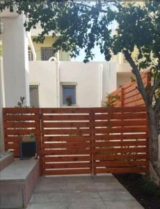 a wooden fence with a tree in front of a building at New studio in the city! in Kos Town
