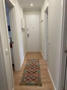 a hallway with a door and a rug on the floor at Dafundo Family Flat in Cruz Quebrada