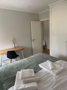 a bedroom with a bed with two white towels on it at Dafundo Family Flat in Cruz Quebrada