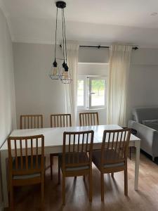 a living room with a dining room table and chairs at Dafundo Family Flat in Cruz Quebrada