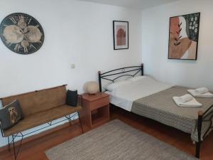 a bedroom with two beds and a clock on the wall at New studio in the city! in Kos