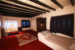 a bedroom with a large bed and a red carpet at Traditional Newari Homestay in Pātan