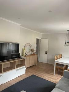 a living room with a television and a dining room at Dafundo Family Flat in Cruz Quebrada