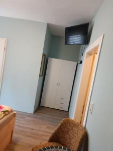 sala de estar con silla y TV en Pension Thüringer Wald en Reichmannsdorf