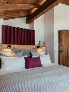 Chalet Nordic mit privatem Whirlpool und Sauna في بايريشزيل: غرفة نوم بسرير كبير وستارة حمراء