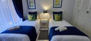 a bedroom with two beds with towels on them at Villa Del Sol Unit 2 in Margate