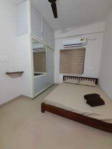 een witte kamer met een bed en een kast bij K-Skuare in Visakhapatnam