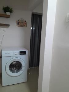 een wasmachine en droger in een kleine kamer bij K-Skuare in Visakhapatnam